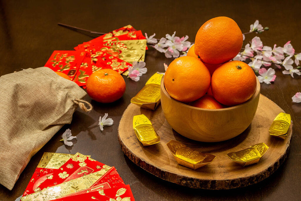 Flat lay mockup per le vacanze Capodanno cinese pacchetto rosso e accessori in oro fiore e sfondo del festival lunare, significa ricchi o ricchi e felicità - Foto, immagini
