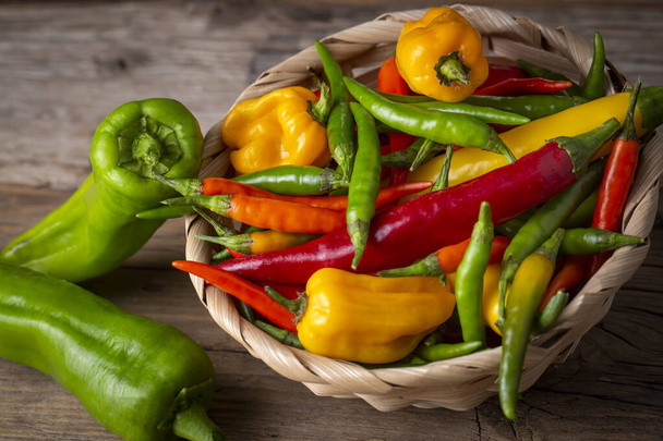 Colorful hot peppers on wooden background - Foto, Imagen