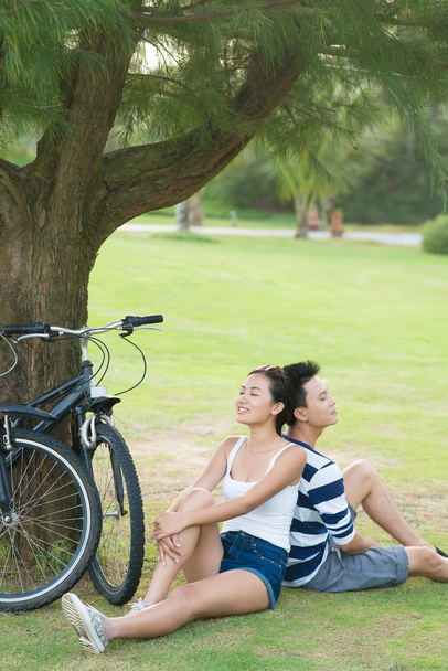Pareja joven relajándose después de andar en bicicleta
 - Foto, imagen