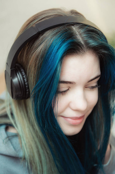 jong tiener meisje met blauw haar en hoofdtelefoon  - Foto, afbeelding