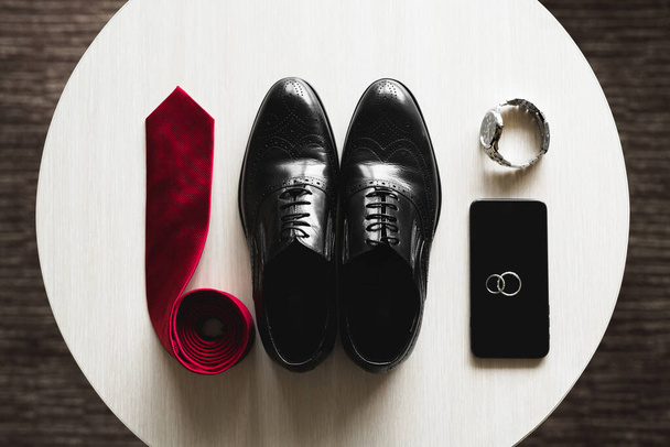 Groom is gathering in the morning.Mens classic shoes, belt,toilette, perfume, leather strap watch, wedding rings - Foto, imagen