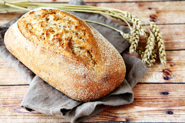 fresh loaf of bread on a linen napkin - Fotoğraf, Görsel