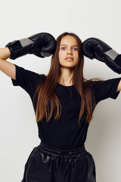 beautiful girl in boxing gloves punch in black pants and a T-shirt fitness training - Foto, Imagem