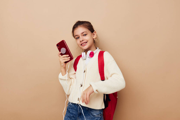 little girl with phone posing red backpack childhood unaltered - Foto, Imagen