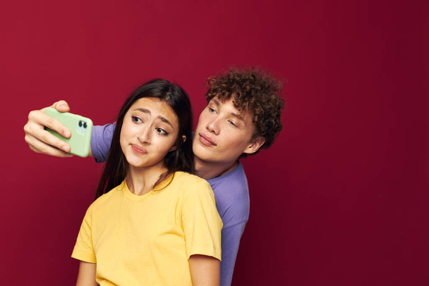 young man and girl take a selfie posing hug isolated background - Foto, Bild