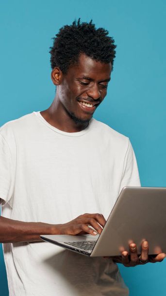 African american man using laptop for entertainment - Photo, Image