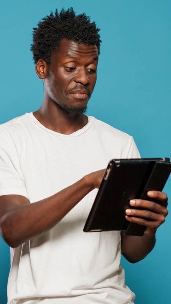 Uomo afroamericano utilizzando tablet digitale e sorridente - Foto, immagini