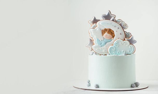 Keresztelő torta kék krémsajt cukormáz díszített mézeskalács cookie-k a fehér háttér. A kis angyalka alszik a Holdon. Gyerek születésű ünneplés. - Fotó, kép
