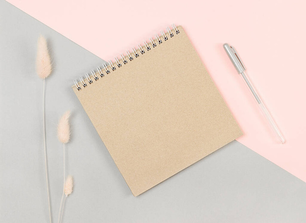 brown notebook and pen on a gray-pink background. View from above - Photo, image