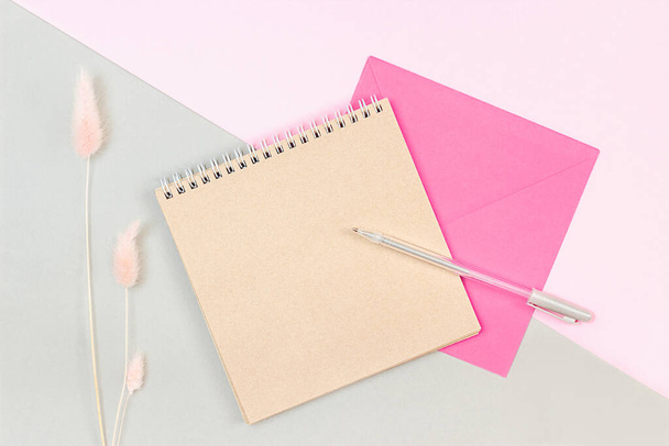 blank notepad and envelope lie on a pink gray background - Fotografie, Obrázek