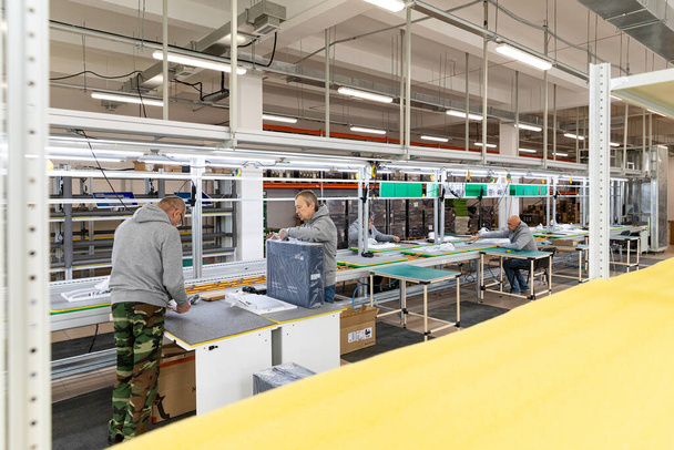 Photo d'une usine d'assemblage de monoblocs pour ordinateurs. Les ouvriers travaillent sur le convoyeur - Photo, image