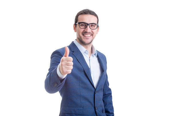 Cheerful businessman smiling broadly stretching hand shows thumb up gesture isolated on white background. Contented business person approvement sign - Photo, image