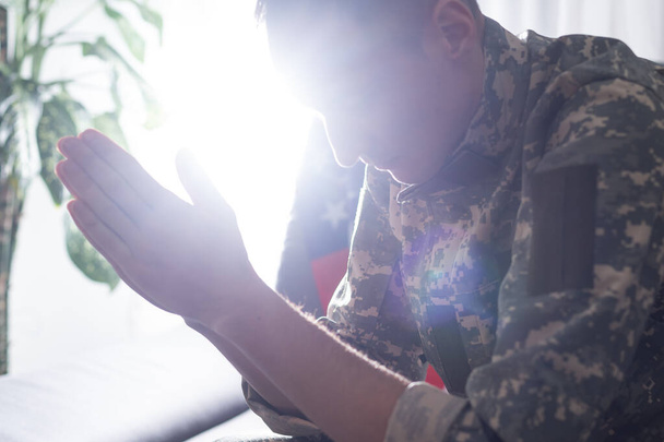 Triest soldaat in uniform die betrekking hebben op zijn mond zittend op een bank - Foto, afbeelding