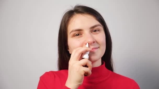 Μια γυναίκα ασθενής σπρώχνει ένα σπρέι στη μύτη για τη θεραπεία της ρινίτιδας, μια αλλεργία με δυσκολία στην αναπνοή - Πλάνα, βίντεο