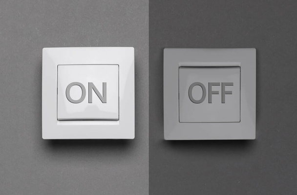 Turned ON and OFF light switches on grey background - Fotó, kép