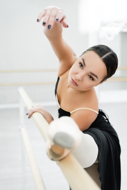 gracieuse femme s'étirant sur la barre en studio de ballet - Photo, image