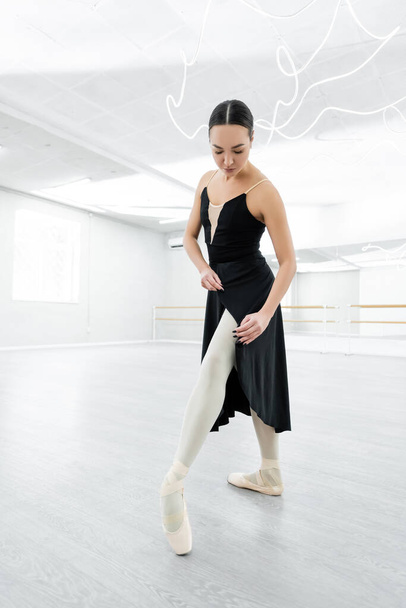 teljes hosszúságú kilátás balerina a fekete ruha próba a táncteremben - Fotó, kép