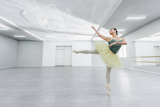 bailarina joven y delgada ensayando danza en estudio de ballet - Foto, Imagen