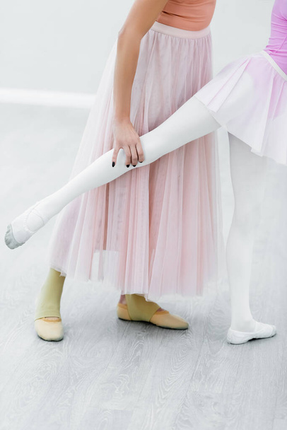 καλλιεργημένη άποψη του κοριτσιού εξάσκηση στοιχεία μπαλέτου κοντά δάσκαλος χορού - Φωτογραφία, εικόνα