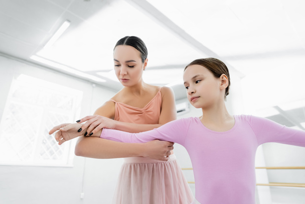 учитель танцев помогает девочке-подростку учиться в балетной школе - Фото, изображение