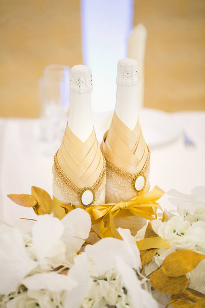 Decorated bottles of champagne on the newlyweds table. - Foto, Imagem
