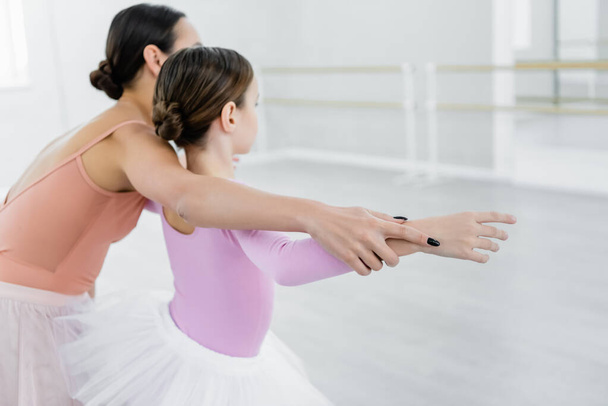 μπαλέτο δάσκαλος βοηθώντας κορίτσι να μάθουν να χορεύουν σε στούντιο μπαλέτου - Φωτογραφία, εικόνα