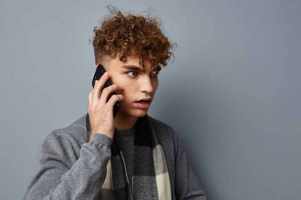 Attractive man in a plaid scarf looking at the phone fashion Lifestyle unaltered - Zdjęcie, obraz