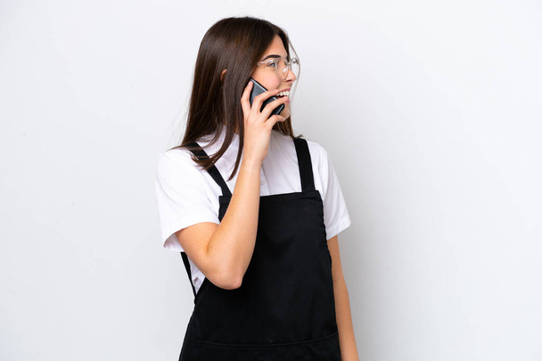 Ristorante Cameriere brasiliano donna isolata su sfondo bianco mantenendo una conversazione con il telefono cellulare con qualcuno - Foto, immagini