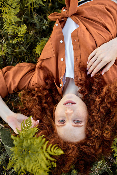 Top View Portrait Of Lovely Caucasian Freckled Lady Lying On Green Grass At Summer - Foto, Bild