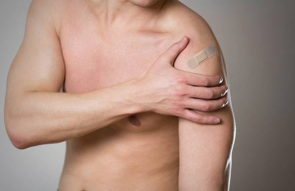 Shoulder pain. The man's shoulder hurts. A Band-Aid. - Photo, Image