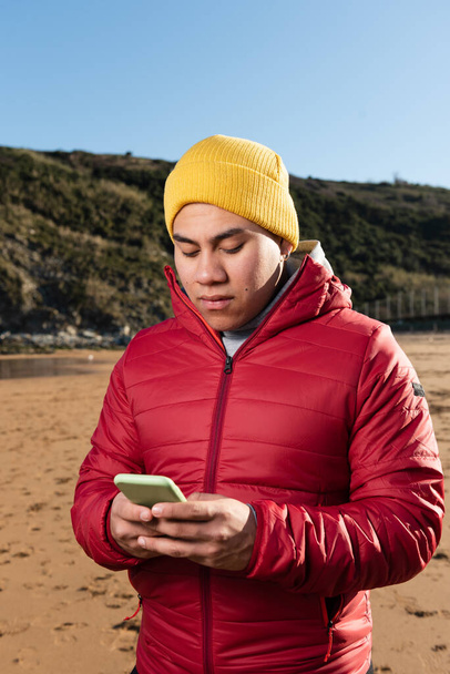 Jovem latino usando telefone e conversando nas mídias sociais - Foto, Imagem