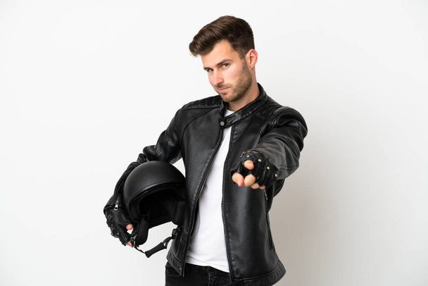 Jovem caucasiano com um capacete de motocicleta isolado no fundo branco apontando frente com expressão feliz - Foto, Imagem