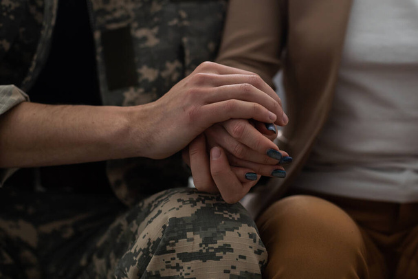 Military man and girlfriend holding hands, supporting boyfriend before leaving - Fotó, kép