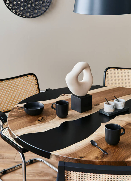 Minimalist composition on the design wooden and epoxy table with black teapot, cups and spoon. Modern dining room interior. Details. Template... - Zdjęcie, obraz
