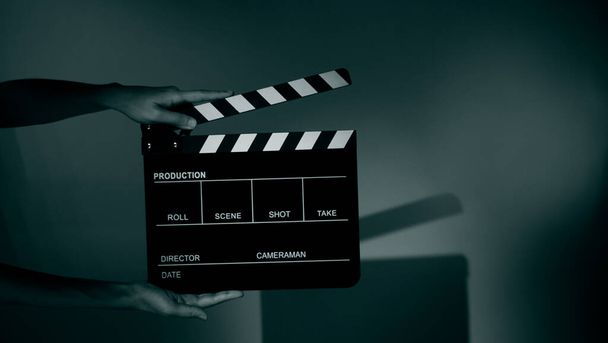 Blurry images of movie slate or clapper board. Hand holds empty film making clapperboard on color background in studio for film movie shooting or recording. Film slate for Youtuber video production. - Fotografie, Obrázek