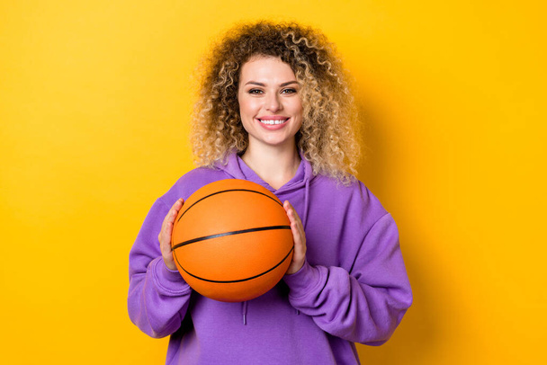 Photo of young cheerful girl hold ball player competition training isolated over yellow color background - Foto, afbeelding