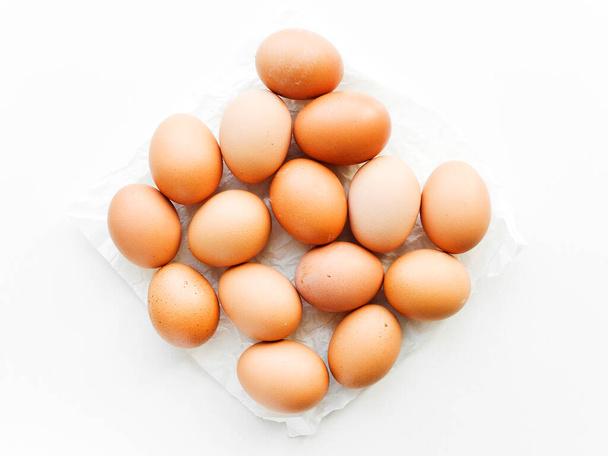 Chicken eggs on the white wooden background. Shallow dof. - 写真・画像