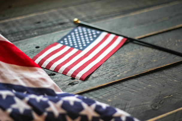 Amerykańska flaga na czarnej drewnianej podłodze oświetlonej od tyłu. w USA - Zdjęcie, obraz