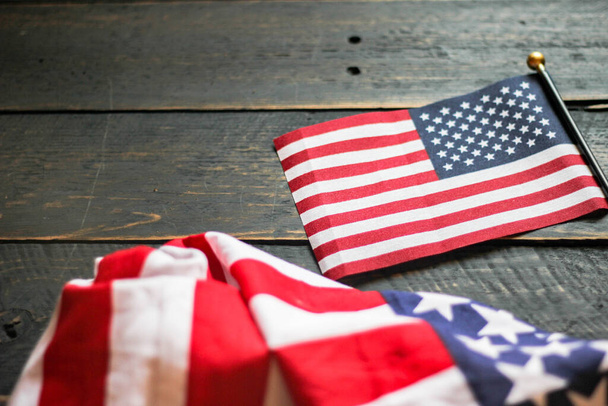 Bandeira americana em um piso de madeira preto iluminado por trás. nos EUA - Foto, Imagem