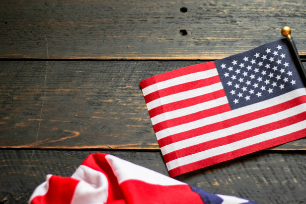 Bandera americana en un suelo de madera negro iluminado por detrás. en Estados Unidos - Foto, Imagen