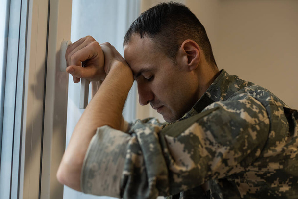 神経質な男性の軍隊はうつ病に苦しんで、自宅で一人で座って、Ptsdの概念 - 写真・画像