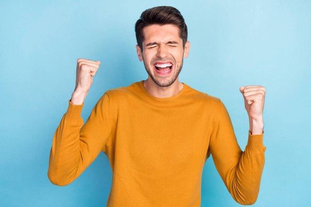 Photo of young cheerful man happy positive smile rejoice win victory lucky success isolated over blue color background - Foto, afbeelding