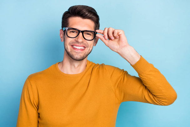 Photo of cool brunet millennial guy hand eyewear wear brown shirt isolated on blue color background - 写真・画像