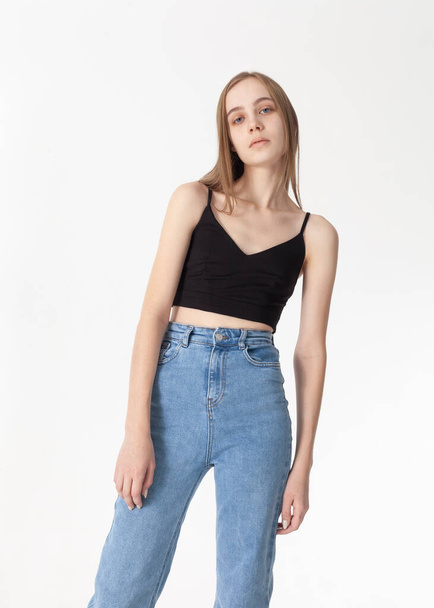 beautiful blonde posing in light jeans and black top - Фото, изображение