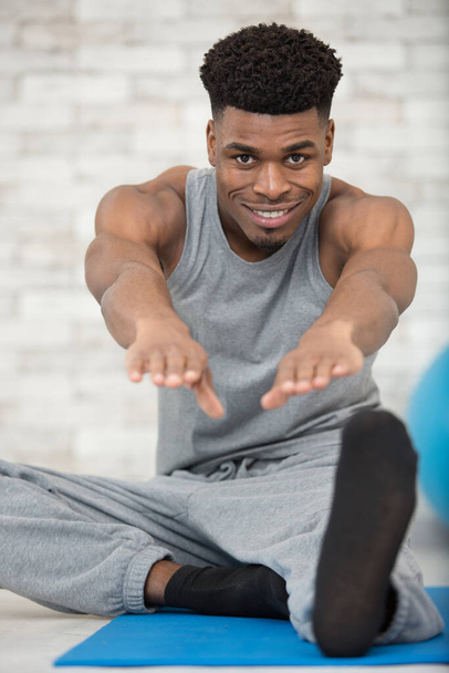 young fit man during home stretch - Фото, зображення