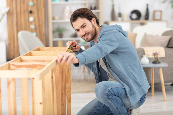 young man assembling furniture at home - Foto, Imagem