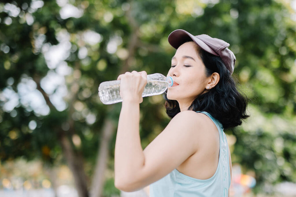 きれいな女性が笑顔で水筒を持っている。健康管理と飲料水の概念は - 写真・画像