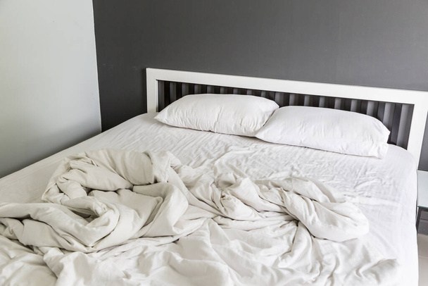 Two white pillow on bed and blanket with wrinkle messy in the bedroom - Foto, afbeelding