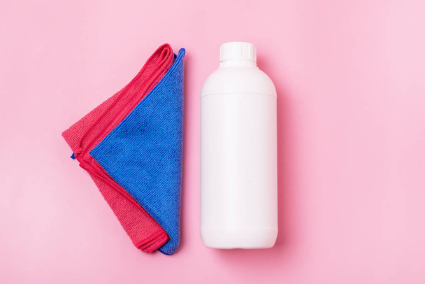 Bílá láhev s čistícím ubrouskem na růžovém pozadí Eco čištění koncepce Povrch s absorpční tkání a láhev čisticího prostředku - Fotografie, Obrázek