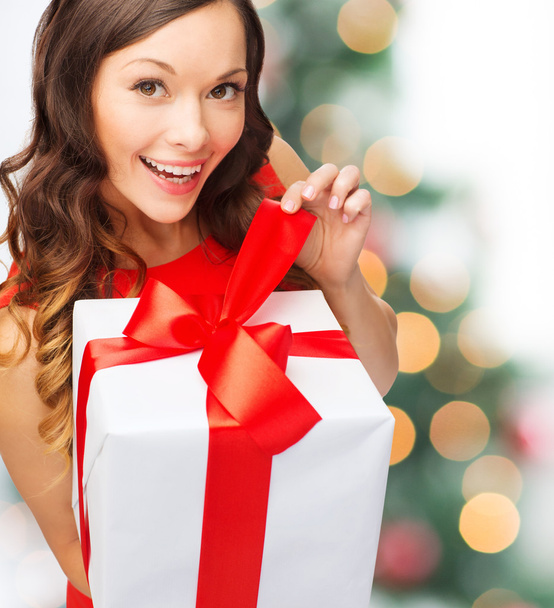 smiling woman in red dress with gift box - Фото, изображение